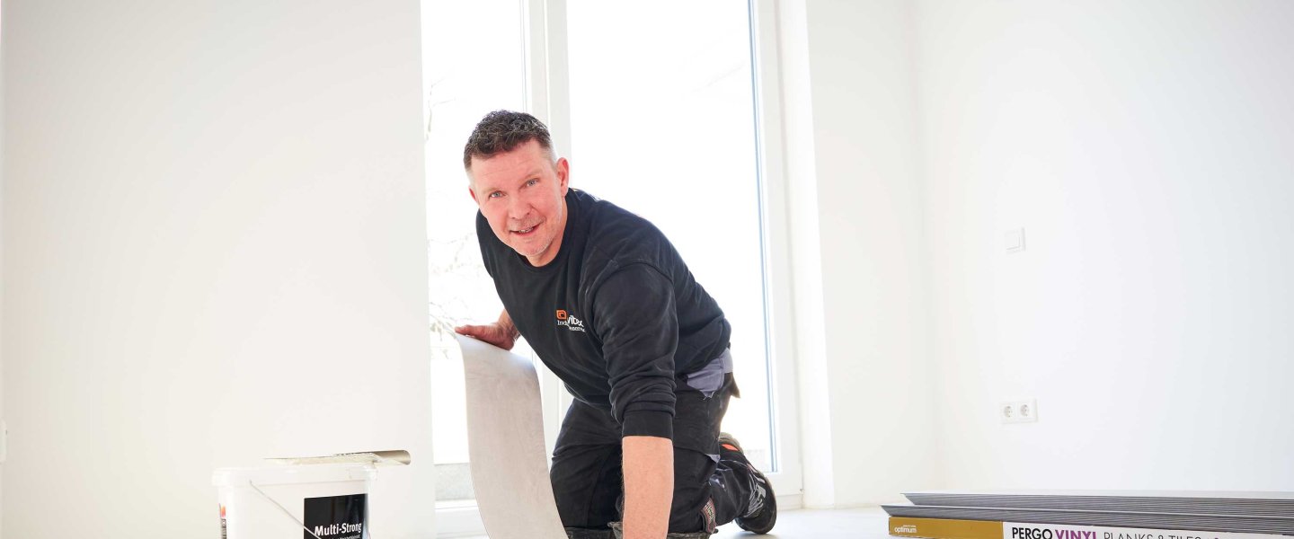 An employee of avitea Industrieservice lays floor coverings