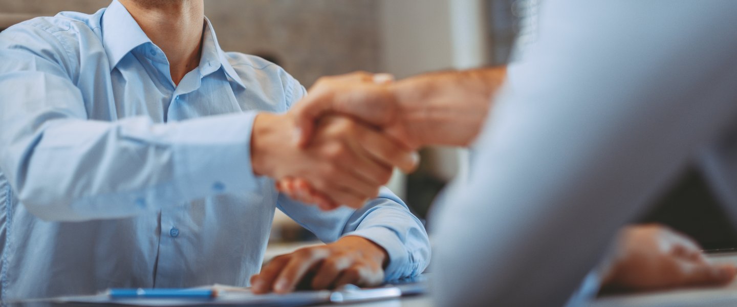 Handshake over a table by two men