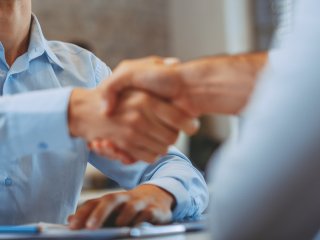 Handshake over a table by two men