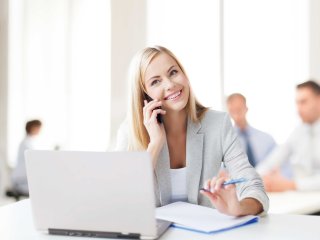 Blonde Frau im Coworking Space am telefonieren 